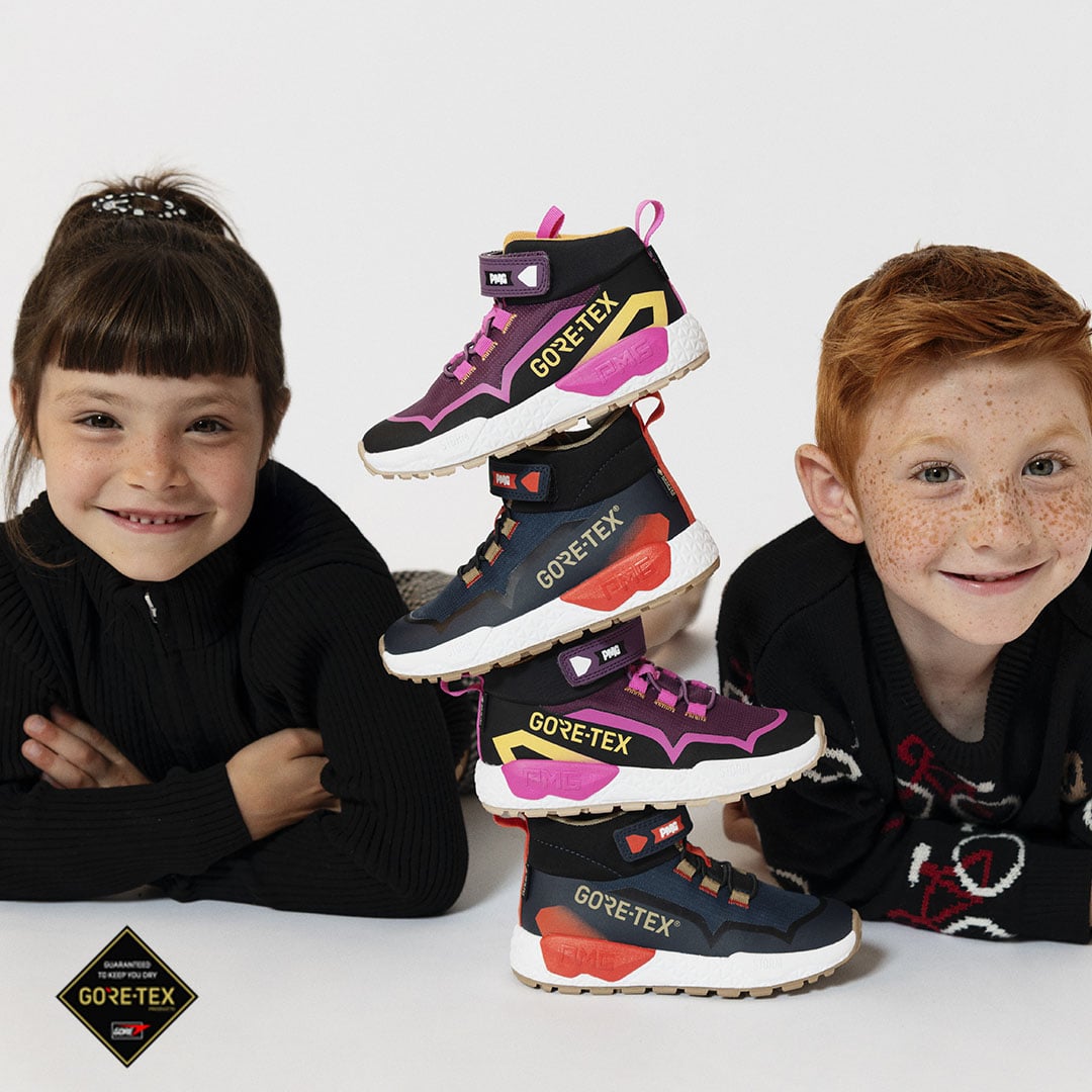 Due bambini che posano accanto a una torre di scarpe GORE-TEX colorate con lacci e dettagli neon.
